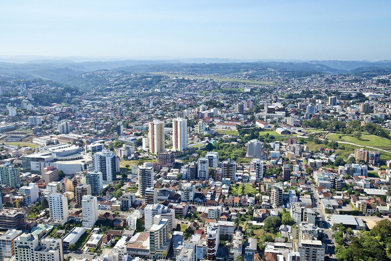 Vista do alto da área urbana de Caxias do Sul, Rio Grande do Sul, com prédios e morros ao fundo